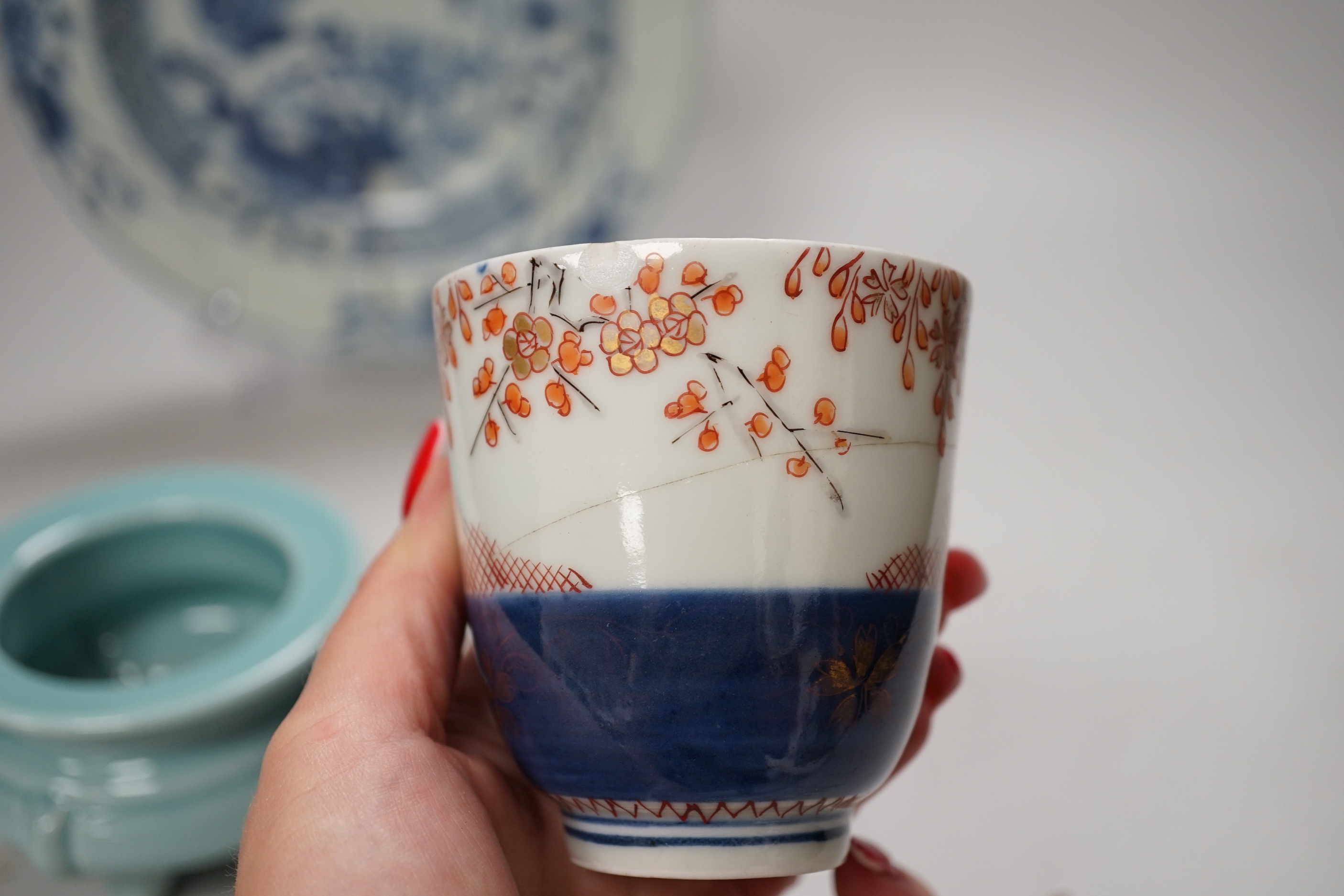 An 18th century Chinese export blue and white dish, celadon glazed tripod censer (20th century) and a Japanese Arita teacup